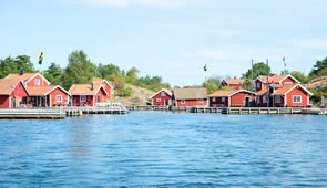 typische rote Häuschen am See in Schweden