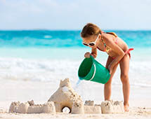Kind baut Sandburgen am Strand