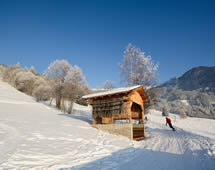 Winterlandschaft mit Schutzhütte und Snowboarder